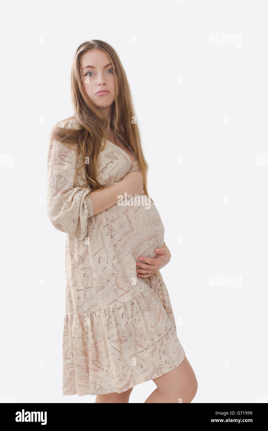 Perplesso, sconvolto donna incinta mentre tiene il suo ventre Foto Stock