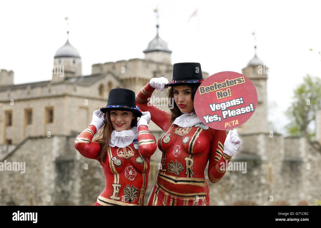 Due modelli, entrambi membri del PETA, con i loro corpi dipinti per assomigliare a Yeoman Warders, promuovono i pasti senza carne in congiunzione con la corsa fino a St George's Day fuori della Torre di Londra. Foto Stock