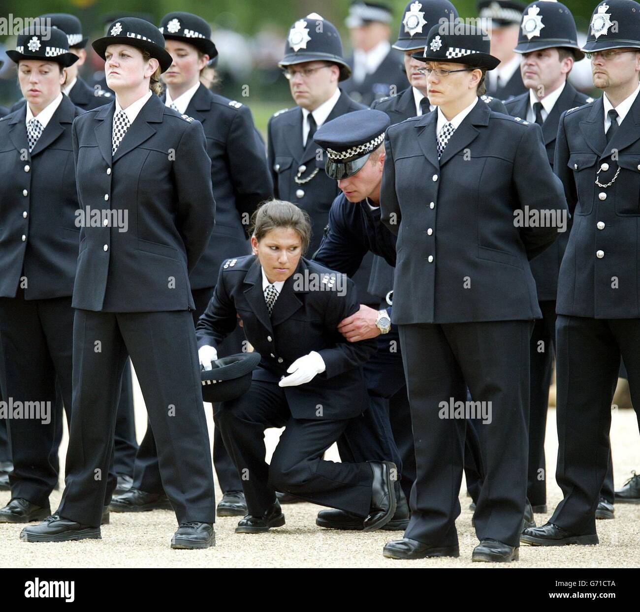 Un poliziotto collassa in occasione di una celebrazione del 175° anniversario del Metropolitan Police Service alla Horse Guards Parade. Foto Stock