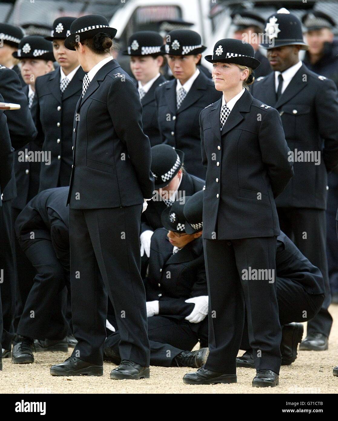 Un poliziotto collassa in occasione di una celebrazione del 175° anniversario del Metropolitan Police Service alla Horse Guards Parade. Foto Stock