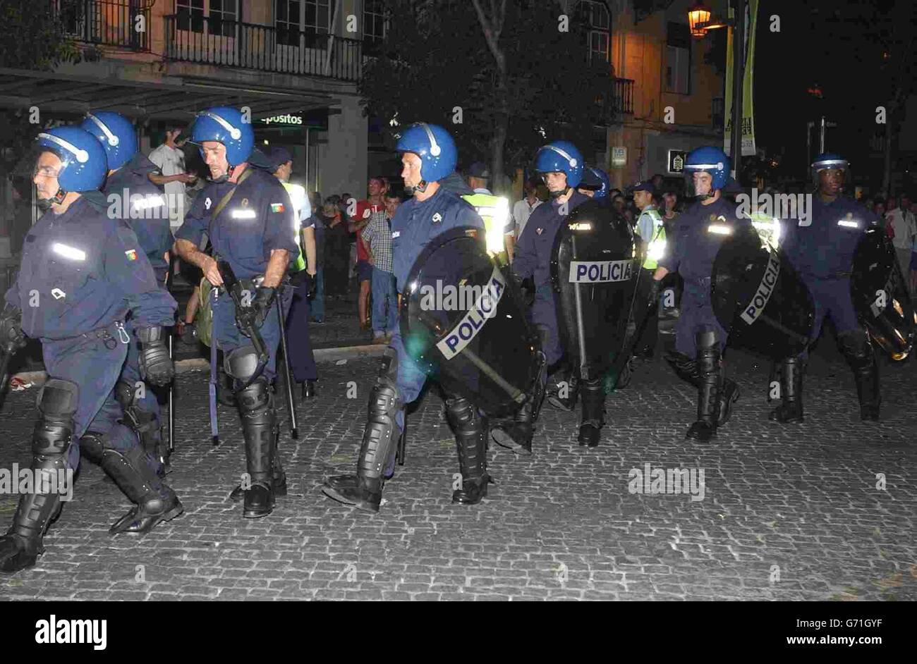 La polizia portoghese in Piazza Rossio a Lisbona, in Portogallo, come i tifosi di calcio inglesi, si godono una serata prima della partita Euro 2004 tra Inghilterra e Francia. Foto Stock