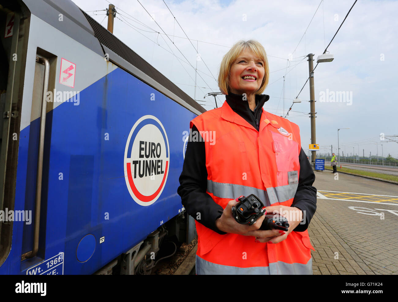 Il responsabile operativo Christine Marsh, che da 20 anni lavora nel sito Eurotunnel di Folkestone, Kent, aiuta a salire a bordo delle autovetture in vista del ventesimo anniversario della creazione del tunnel tra Regno Unito e Francia. 25/4/14 Foto Stock