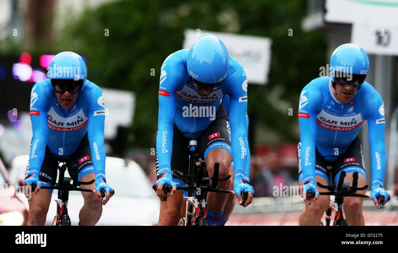 I membri del team Garmin Sharp attraversano la linea dopo aver perso un certo numero di membri a causa di un incidente durante la prova a tempo del Team del giro D'Italia 2014 a Belfast. Foto Stock