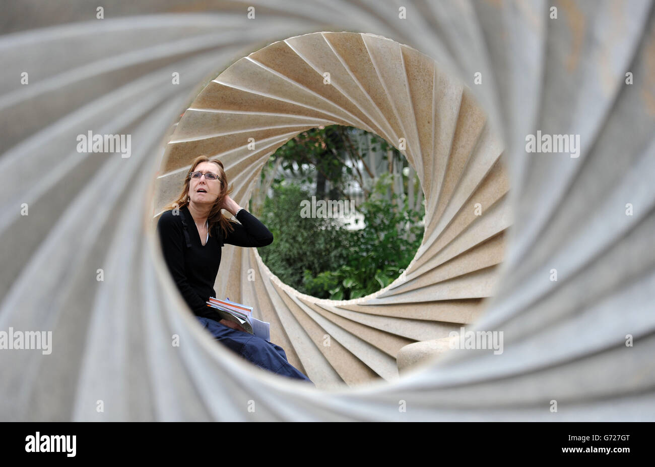 Un membro del pubblico da una scultura di Nicolas Moreton al RHS Chelsea Flower Show, presso il Royal Hospital di Chelsea, Londra. Foto Stock