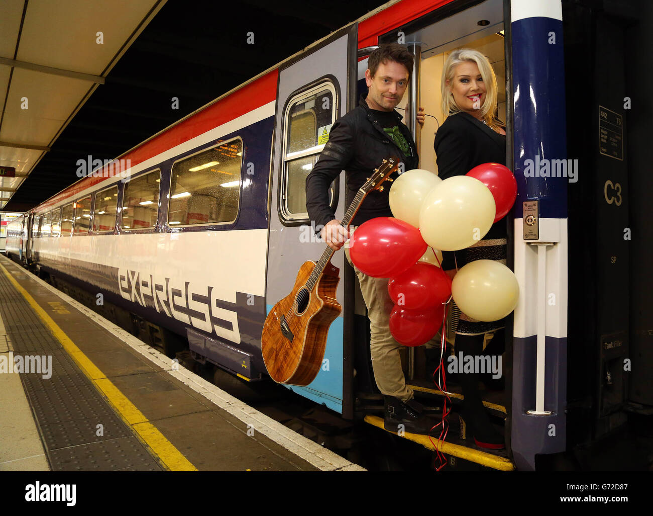 SOLO PER USO EDITORIALE Kim Wilde festeggia il trentesimo compleanno del Gatwick Express con una performance a sorpresa con il suo chitarrista Steve Streater per i passeggeri che viaggiano da Londra Victoria a Gatwick. Foto Stock