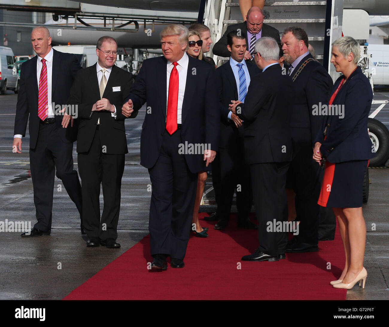 IL magnate STATUNITENSE Donald Trump (centro) arriva all'aeroporto di Shannon in Irlanda per visitare il campo di Doonbeg dopo aver ottenuto il via d'uscita dai capi del consiglio per costellare il famoso quattordicesimo verde sul campo, A seguito di un accordo per svolgere il lavoro su un sistema di dune protette che corre accanto al suo resort di lusso golf nella parte occidentale dell'Irlanda. Foto Stock