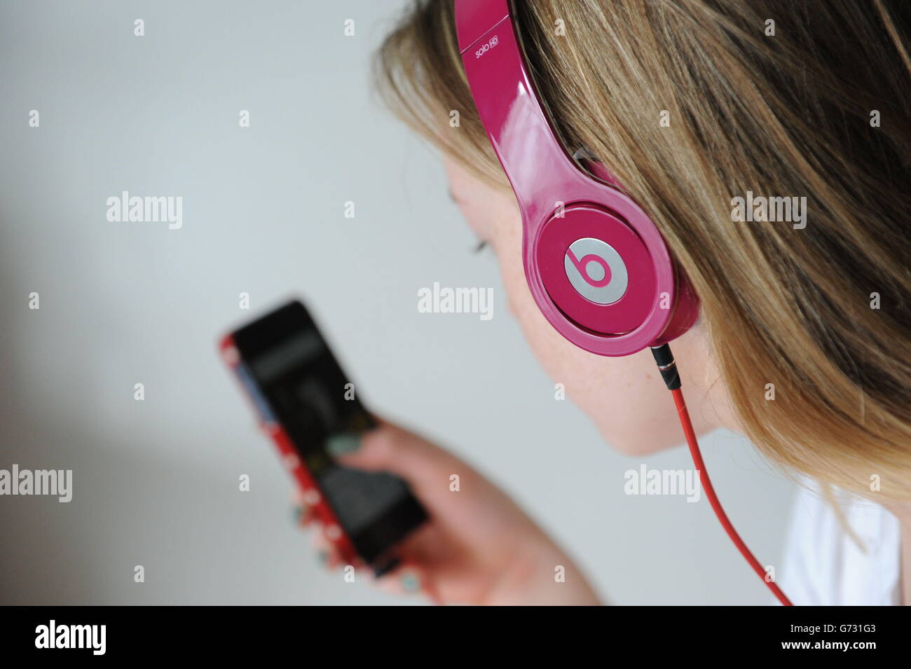 Un adolescente utilizza un paio di cuffie solo HD Beats da Dr Dre e un  Apple iPhone, come Apple farà l'acquisizione più costosa nella sua storia,  dopo aver confermato un accordo per