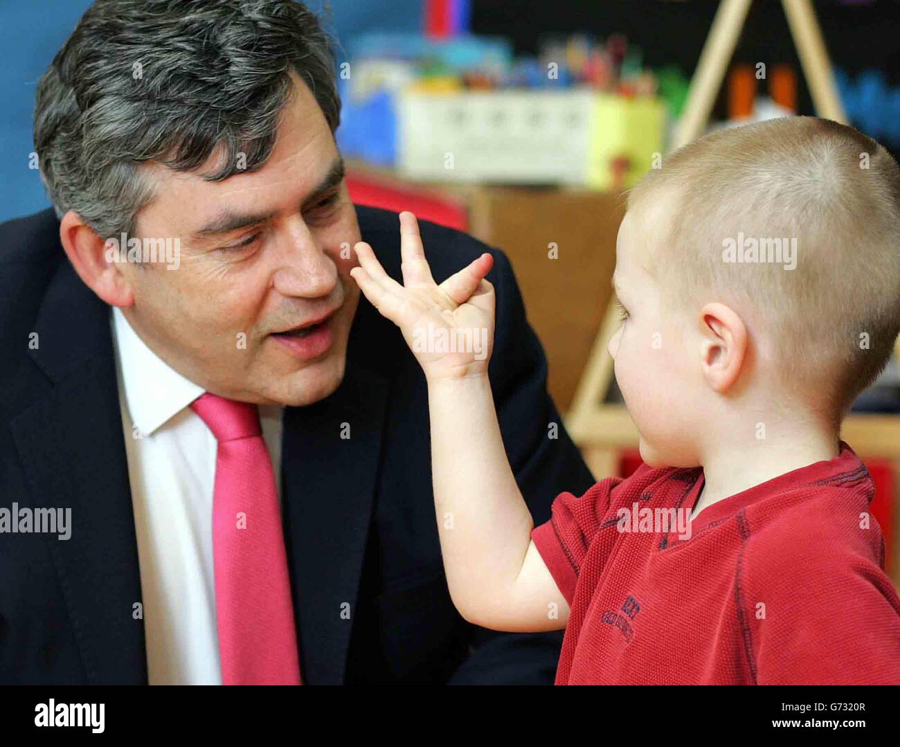Il Cancelliere britannico dello scacchiere Gordon Brown parla con i bambini durante una visita al Bessborough Day Nursery nel centro di Londra. Foto Stock