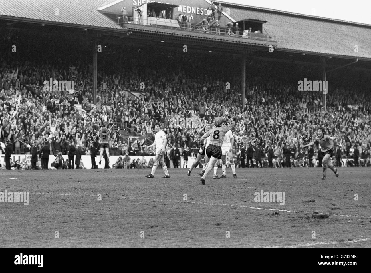 Willie Carson di Wolverhampton Wanderers festeggia il punteggio di una penalità paralizzante dell'ultimo minuto per legare la partita 2-2. I fan possono essere visti seduti di fronte alle schede pubblicitarie a causa della congestione della folla. Foto Stock