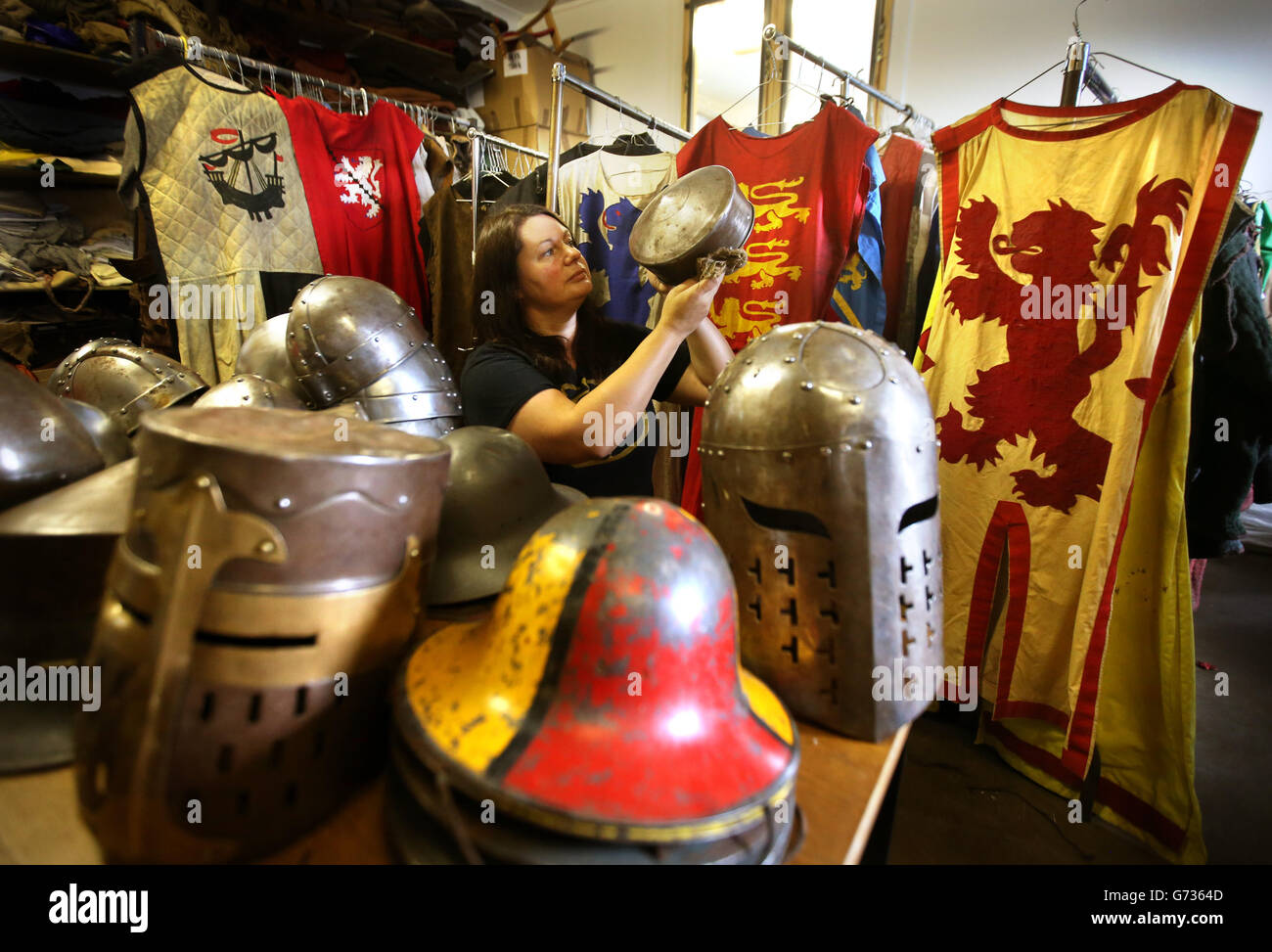 Annette Grier dal Clanranald Trust Tentes vede un casco mentre si allinea, Lucida e fissa le cinghie ai caschi, oltre a regolare i costumi durante i preparativi finali per la Battaglia di Bannockburn che si terrà a Bannockburn Live Event a Bannockburn il 28 e 29 giugno, come la Battaglia di Bannockburn del 700 ° anniversario è celebrato. Foto Stock