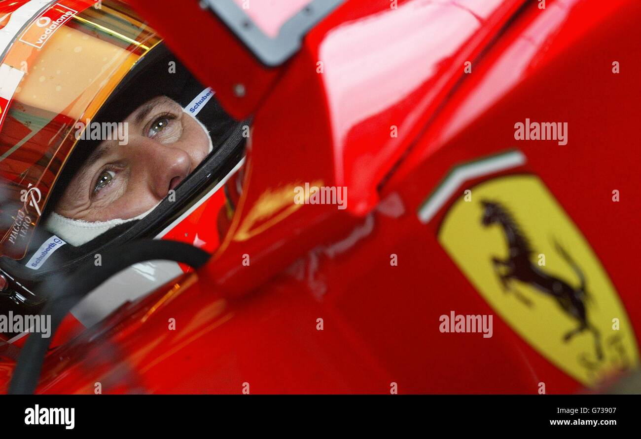 Il campione del mondo di Formula uno Michael Schumacher guarda i tempi sul giro degli altri piloti dai box Ferrari durante la prima sessione di prove sul circuito di Silverstone, nel Northamptonshire, in preparazione al Gran Premio di domenica. Foto Stock