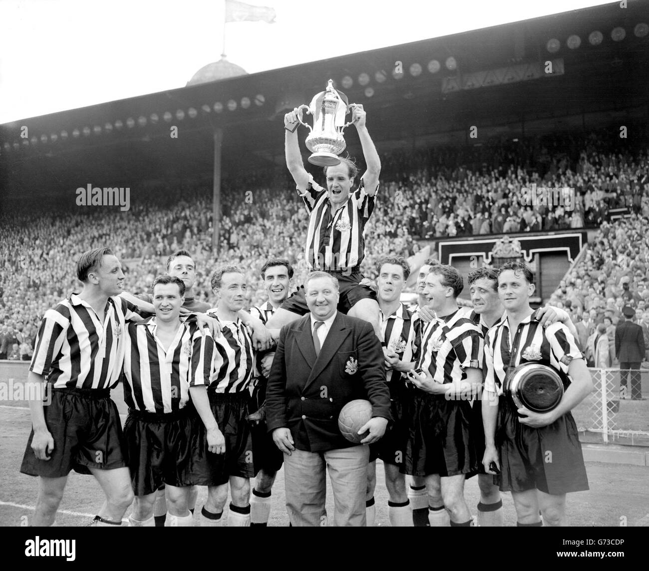 Jimmy Scoular, capitano della Newcastle United, solleva la fa Cup Aloft, che ha appena ricevuto dalla regina, dopo aver battuto Mancheste City 3-1 in finale a Wembley. Fu la loro terza vittoria in cinque anni, un record per questo secolo. Foto Stock