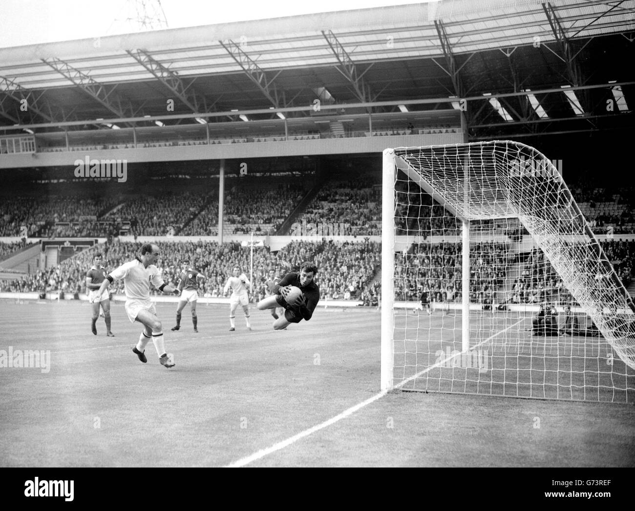 Costa Pereira, portiere del Benfica FC (Portogallo), si tuffa per salvare un colpo da sani, all'interno-destra di Milano AC (Italia), nella finale della European Champions Clubs' Cup a Wembley. Foto Stock