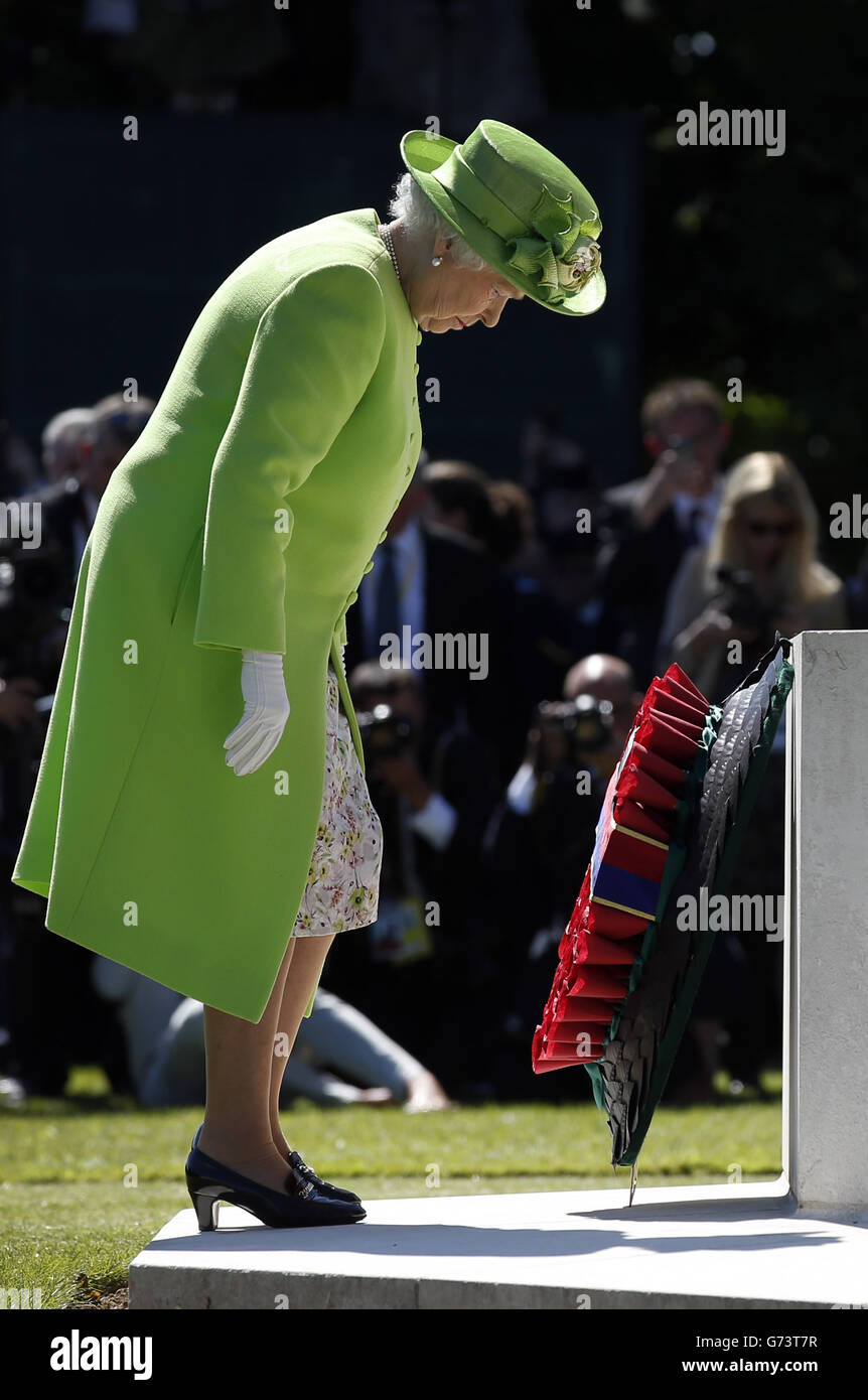 La regina Elisabetta II depone una corona ai piedi della Croce del sacrificio, nel centro del Commonwealth War Graves Commission Cemetery, Bayeux, durante un servizio di memoria, Normandia, Francia. Foto Stock