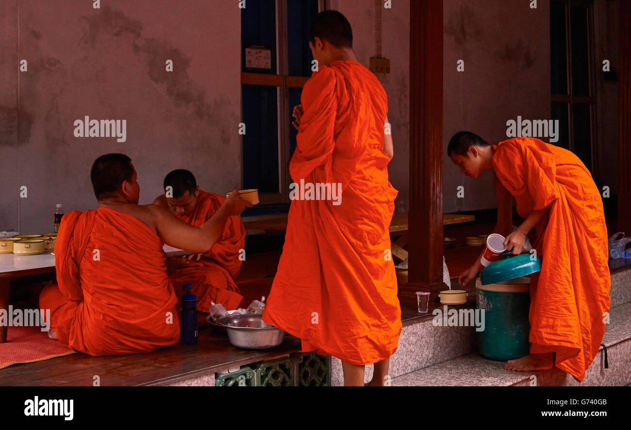 Monaco buddista avente la colazione la mattina dopo la raccolta di elemosina. Bangkok, Thailandia Foto Stock