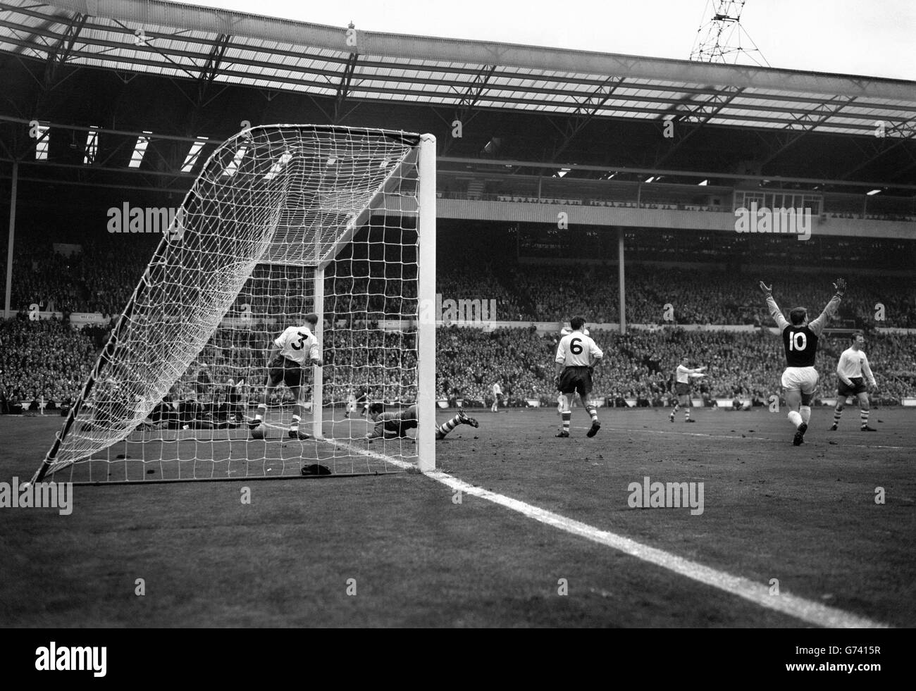 Con le braccia in alto, West Ham's Inside-left Hurst si allontana dopo aver segnato il secondo obiettivo di equalizzazione all'inizio della seconda metà della finale della fa Cup contro Preston North End a Wembley. Il portiere Kelly è sui gomiti e sulle ginocchia mentre Smith aggancia la palla dalla rete. Torna alla telecamera Kendall, 17 anni a sinistra con Preston e il giocatore più giovane a comparire in una finale di Coppa. West Ham ha vinto 3-2. Foto Stock