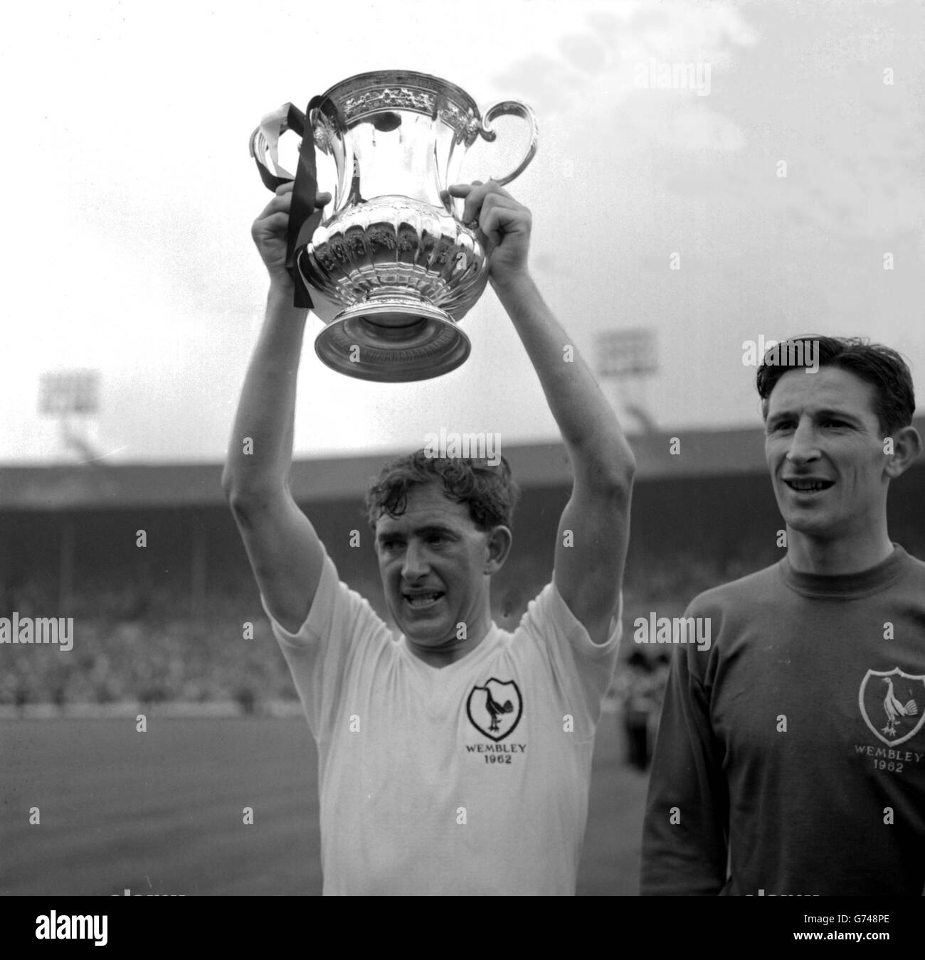 Danny Blanchflower, a destra e Capitano di Tottenham Hotspurs, solleva la tazza fa in modo che migliaia di fan di Spurs gioiosi possano dare un'occhiata. Gli spur hanno vinto il trofeo per il secondo anno consecutivo, dopo aver battuto in finale Burnley 3-1 Foto Stock