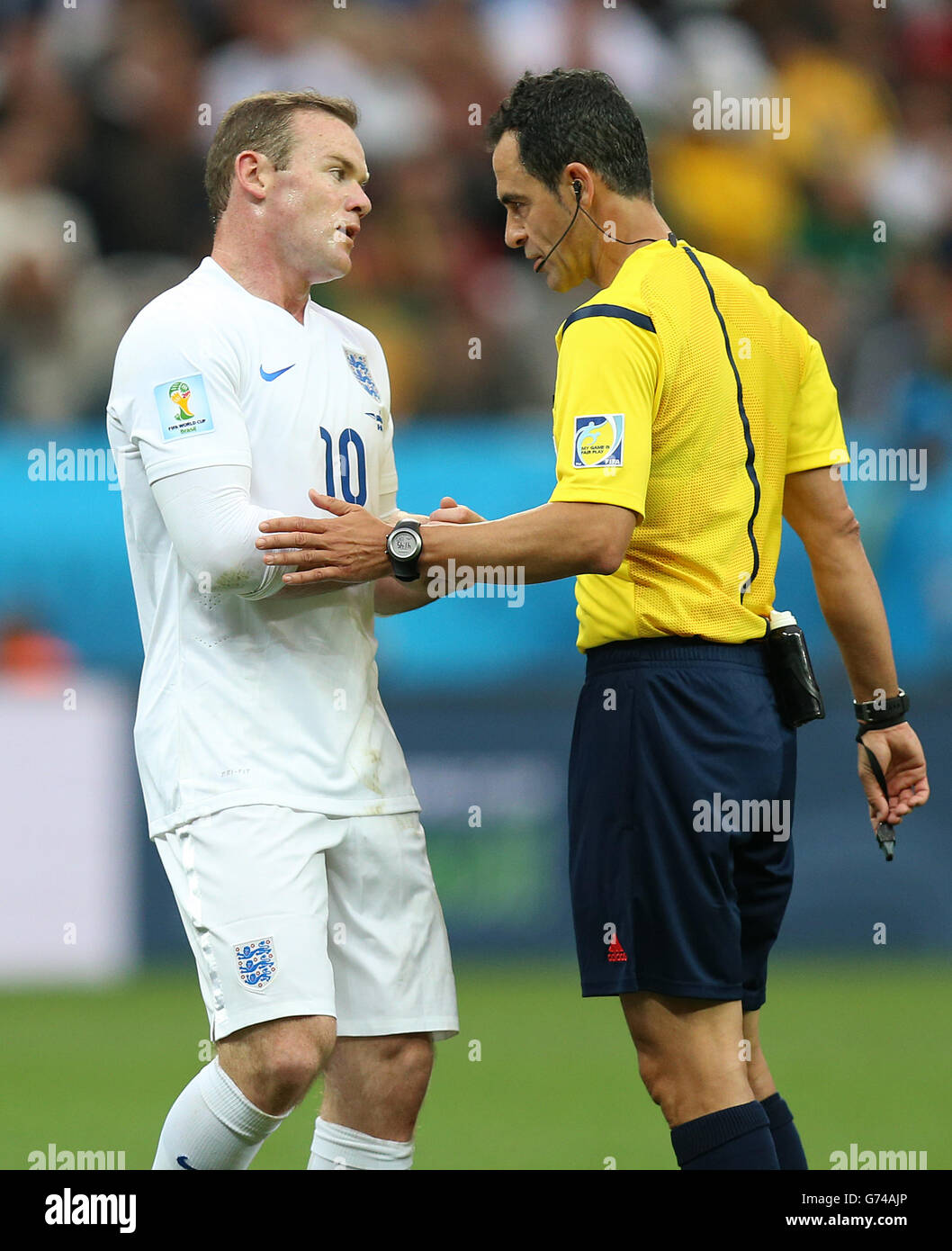 Wayne Rooney in Inghilterra parla con l'arbitro Carlos Velasco Carballo durante la partita del gruppo D l'Estadio do Sao Paulo, San Paolo, Brasile. Foto Stock