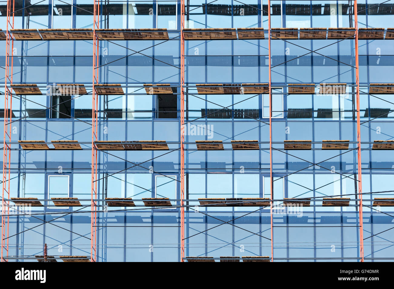 Ufficio di vetro edificio in costruzione con i ponteggi Foto Stock