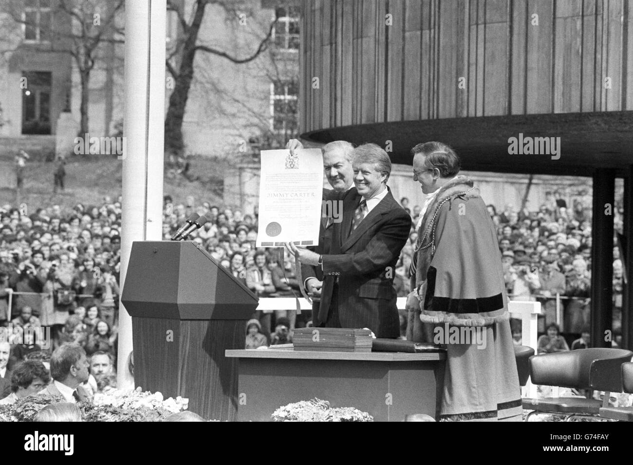 Il presidente Jimmy carter tiene in mano un rotolo che gli è stato presentato dal sindaco del consigliere di Newcastle Hugh White, durante una cerimonia fuori dal centro civico della città. Il presidente è stato reso un onorario freeman della città, e si è endeed alla folla di oltre 20,000 con un grido rallying di 'Awa 'il Lads'. Dietro carter c'è il primo ministro James Callaghan. Foto Stock