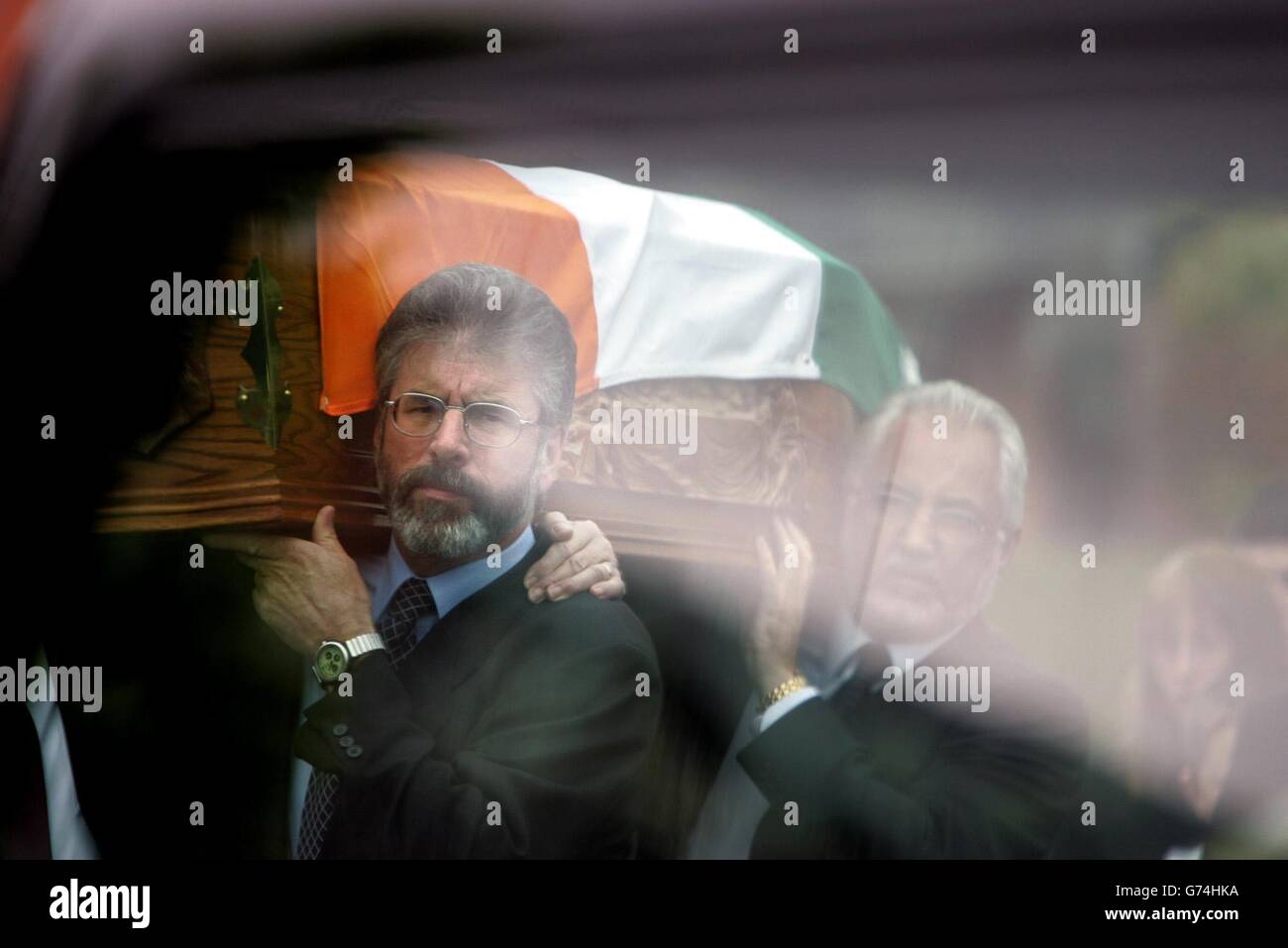 Il presidente del Sinn Fein Gerry Adams porta la bara del reduci Joe Cahill, lungo la Andersonstown Road a West Belfast fino alla chiesa di St John sulla Falls Road. Il vice-presidente del partito ed ex capo di stato maggiore dell'IRA, Cahill, è morto durante il fine settimana a causa dell'asbestosi di 84 anni e i suoi funerali hanno portato Belfast ad ovest a fermarsi. Adams ha detto ai repubblicani alla graveside di Cahill che gli elementi all'interno del governo britannico erano da imputare per l'impasse nel processo di pace. Foto Stock