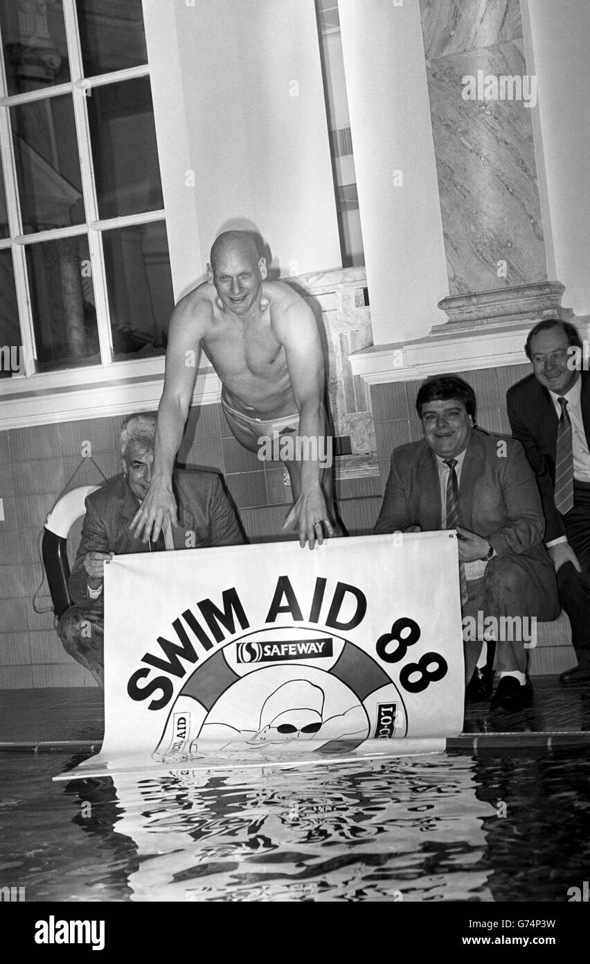 Il nuotatore Duncan Goodhew lancia Swim Aid 88, con l'aiuto del giocatore di freccette Jocky Wilson (a destra) e del commentatore dello sport Ron Pickering. La campagna intende incoraggiare le autorità locali ad ospitare eventi di beneficenza per finanziare progetti di sviluppo a lungo termine in Africa. Foto Stock