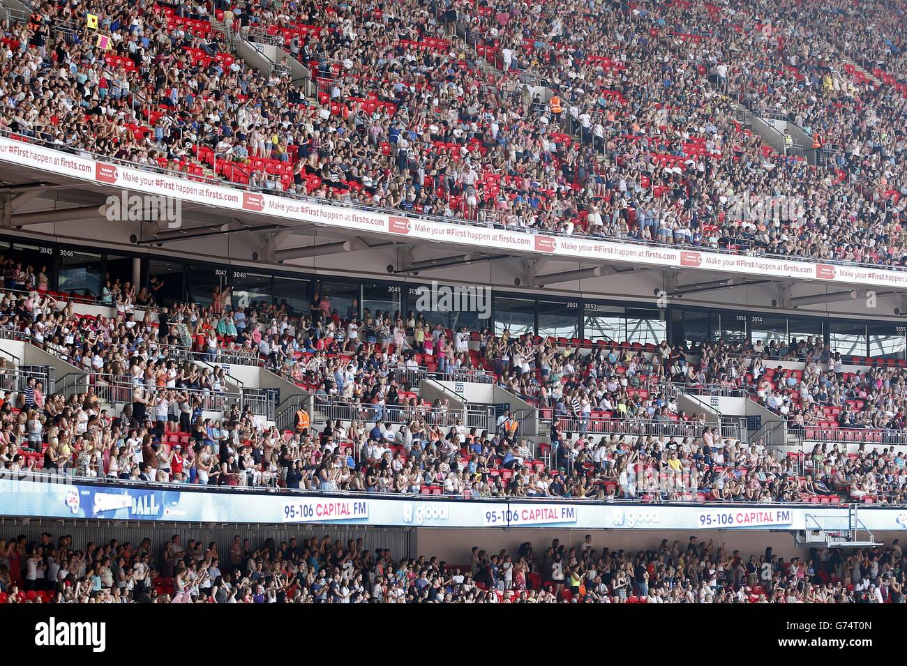 I tifosi guardano Calvin Harris esibirsi durante il Summertime Ball della capitale FM al Wembley Stadium, Londra. Foto Stock