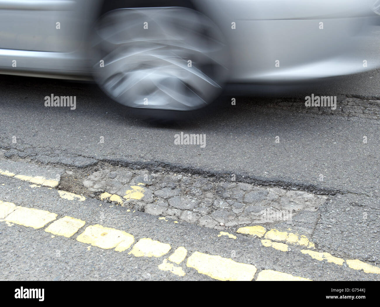 Un'automobile guida sopra un pothole su una strada in Kimberley, Nottingham Foto Stock