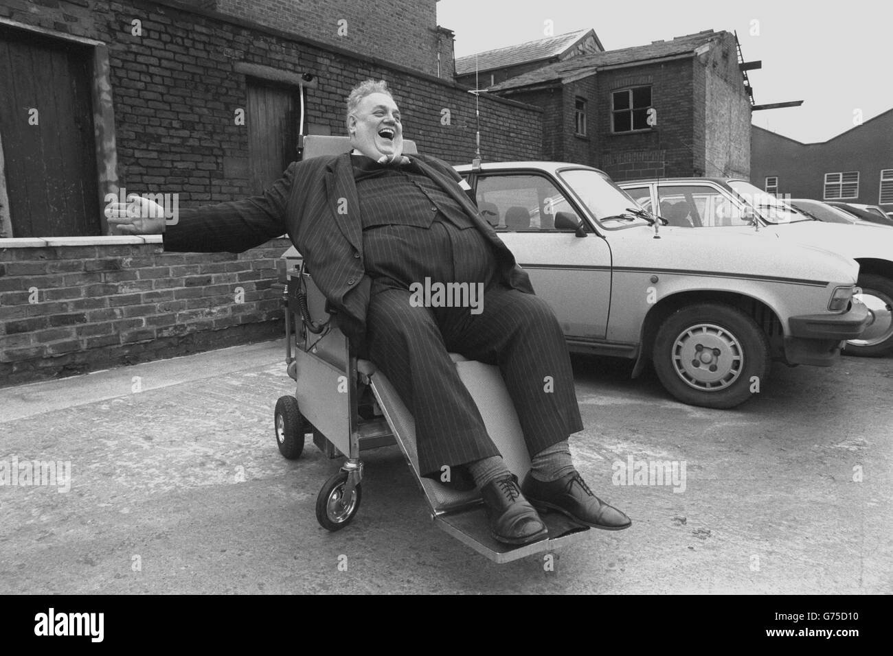 Cyril Smith, il deputato liberale di Rochdale, segnala una svolta a destra durante la prova di una sedia a rotelle motorizzata, che si converte in una barella, ad Ashton-under-Lyne. Il figlio-cervello di un uomo d’affari della Greater Manchester, Clive Williams, fa risparmiare agli infermieri la necessità di sollevare pazienti pesanti o anziani per dormire. Foto Stock