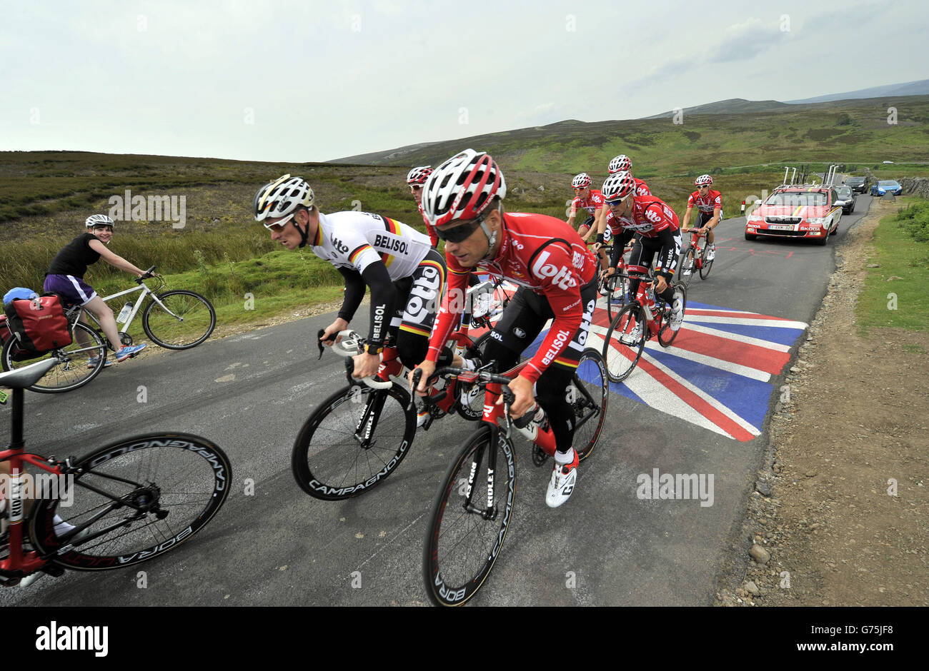 Un ciclista dilettante si ferma (a sinistra) mentre il Lotto Belisol Team  affronta una salita nei pressi di Leyburn durante una corsa di allenamento  per la prima fase della gara tra Leeds