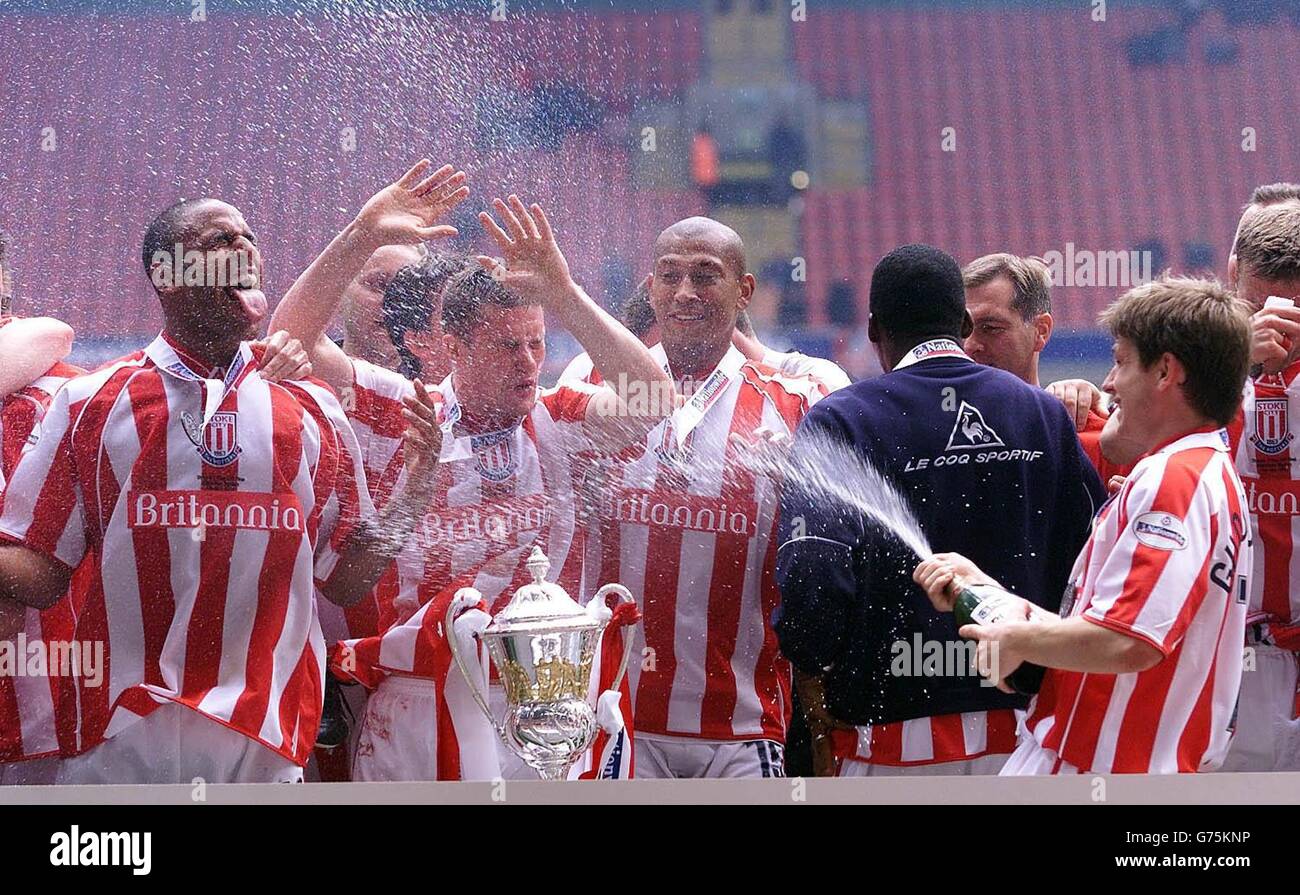 Il Bjarni Gudjonsson di Stoke City spruzza i suoi compagni di squadra con champagne in festa dopo la vittoria di Brentford nel 2-0 nella finale di due partite della Nationwide Division tra Brentford e Stoke al Millennium Stadium di Cardiff. . Foto Stock