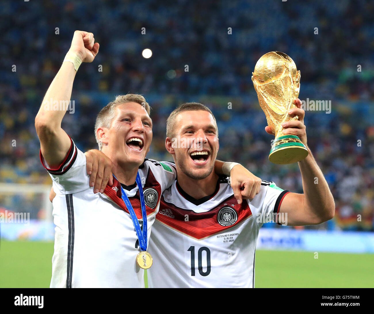 Il Bastian Schweinsteiger della Germania (a sinistra) e Lukas Podolski festeggiano sul Piazzati con il Trofeo FIFA World Cup 2014 Foto Stock