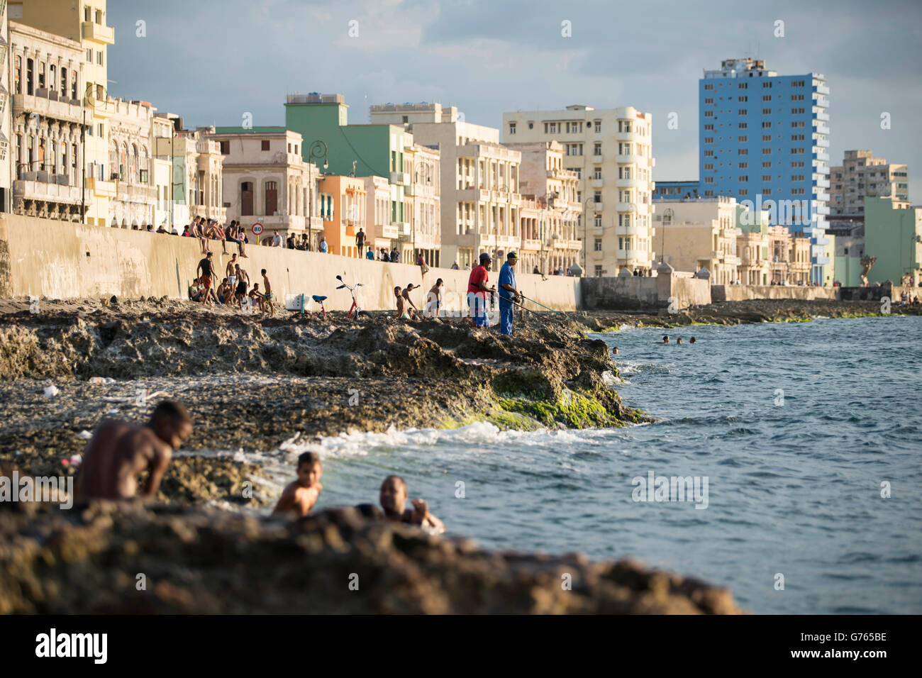 Persone di pesca dalle rocce di fronte al Malecon (strada costiera) in Havana, Cuba Foto Stock