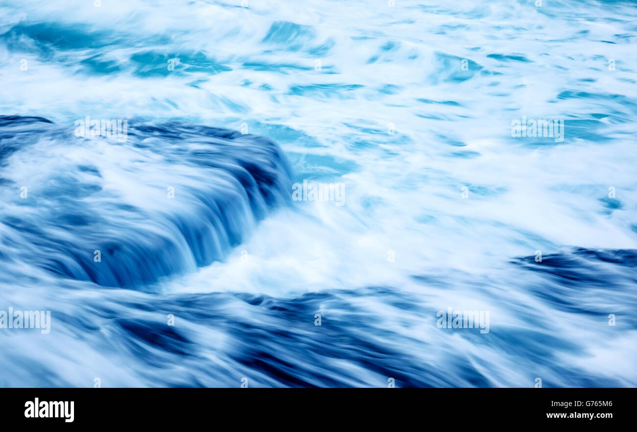 Slow motion sfondo onde, bellissimo mare tempestoso, streaming di acqua sulle rocce, astratto blu sfondo naturale Foto Stock