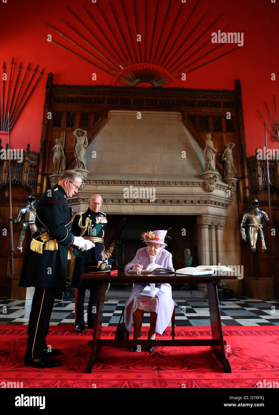La regina Elisabetta II firma il libro degli ospiti presso la Great Hall del Castello di Edimburgo dopo aver partecipato a un servizio commemorativo per il memoriale di guerra nazionale scozzese presso il Castello di Edimburgo. Foto Stock