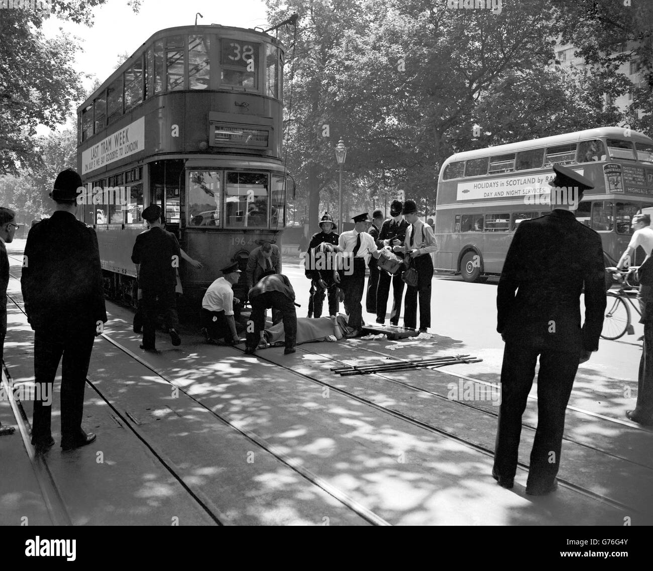 Nell'ultima settimana in cui le automobili del tram correranno a Londra, una donna è ferita quando è entrato in contatto con un tram sul Victoria Embankment. Nella foto sono raffigurate le donne che giacciono su una barella sulla carreggiata, in attesa di essere trasportate in un'ambulanza. Foto Stock