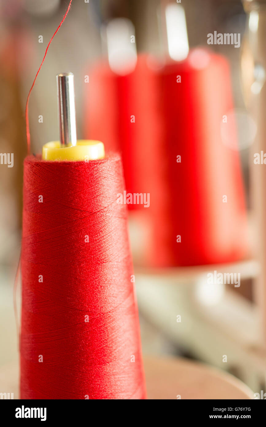 Bobina di filo rosso su una macchina da cucire il pin Foto Stock