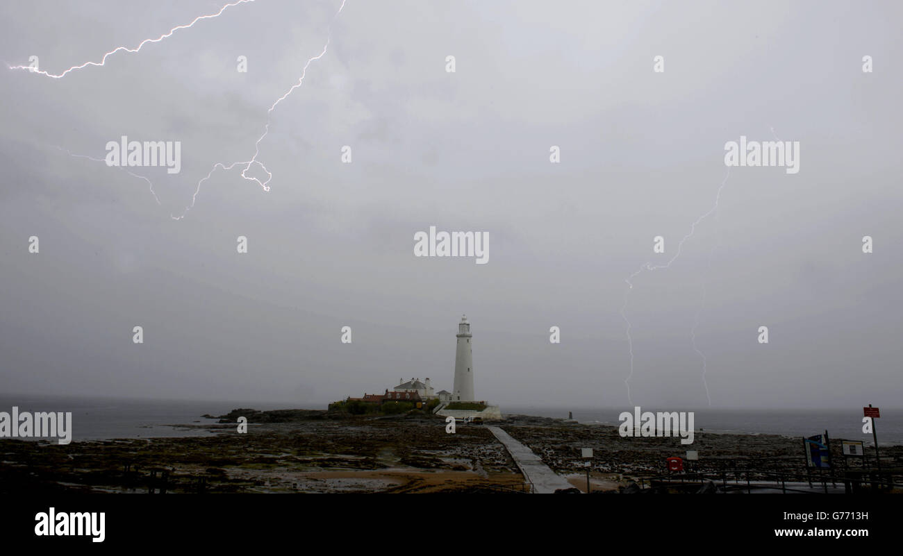 I fulmini colpiscono il faro di St Mary nel Northumberland, mentre si prevede che le tempeste di tuoni colpiscano la regione oggi. Foto Stock
