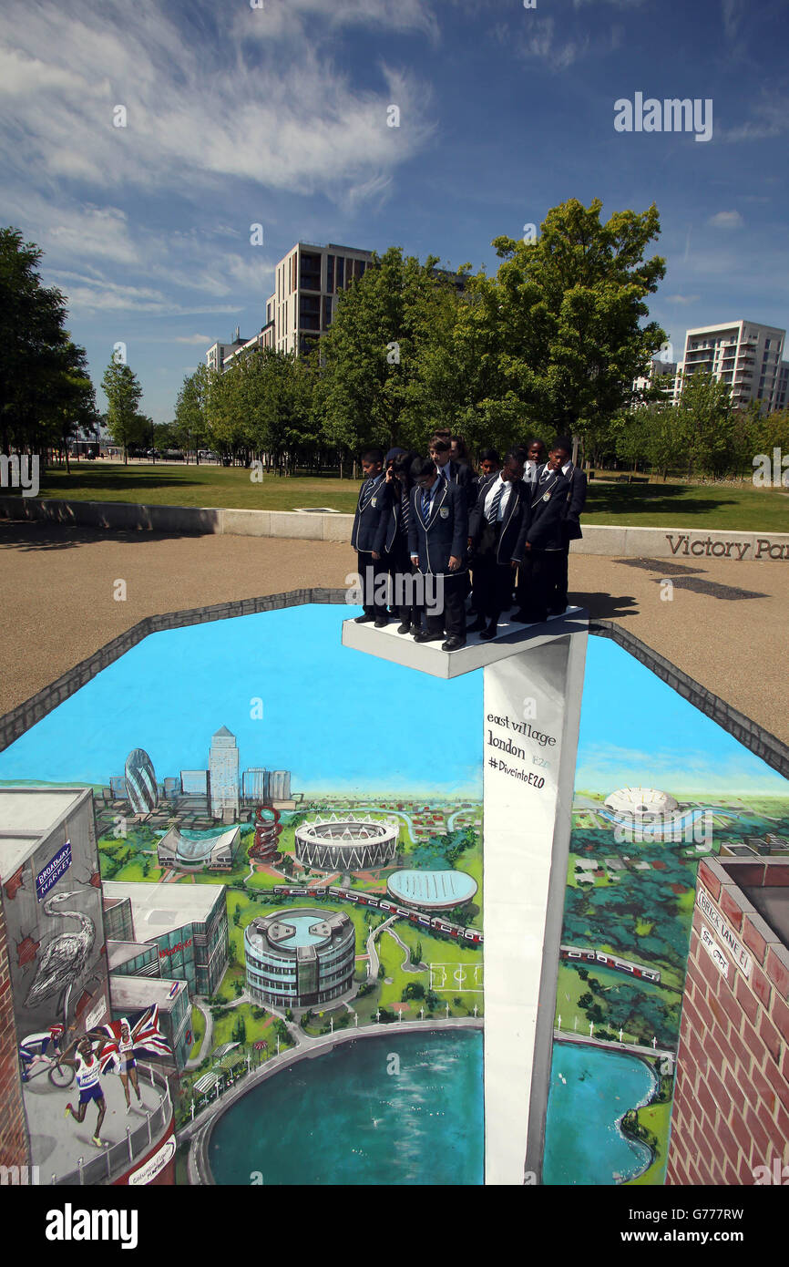 Gli studenti della Chobham Academy, Londra, si preparano a tuffarsi in un pezzo d'arte in 3D che raffigura il paesaggio della parte orientale di Londra, il Queen Elizabeth II Olympic Park e i cammei di Londra 2012, creati dagli artisti 3D Joe e Max, presso l'East Village di Londra. Foto Stock