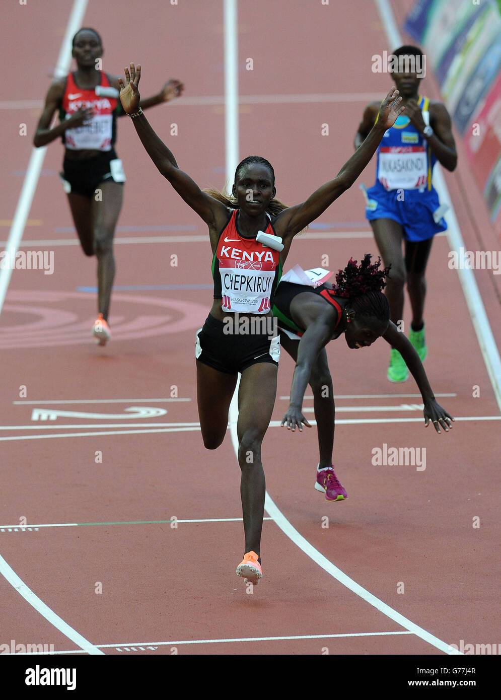 Joyce Chepkirui in Kenya festeggia la vittoria mentre il secondo compagno di squadra Florence Kiplagat cade sopra la linea nella finale femminile di 10.000 m a Hampden Park, durante i Giochi del Commonwealth 2014 a Glasgow. Foto Stock