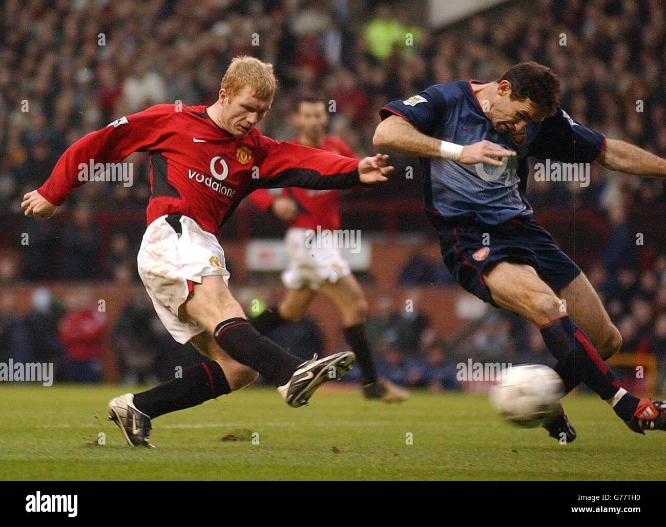 Paul Scholes (a sinistra) del Manchester United batte la palla oltre Martin Keown of Arsenal per segnare il secondo gol per il Manchester United, durante la Barclaycard Premiership Match a Old Trafford, Manchester. Manchester United ha vinto il gioco 2-0. Foto Stock