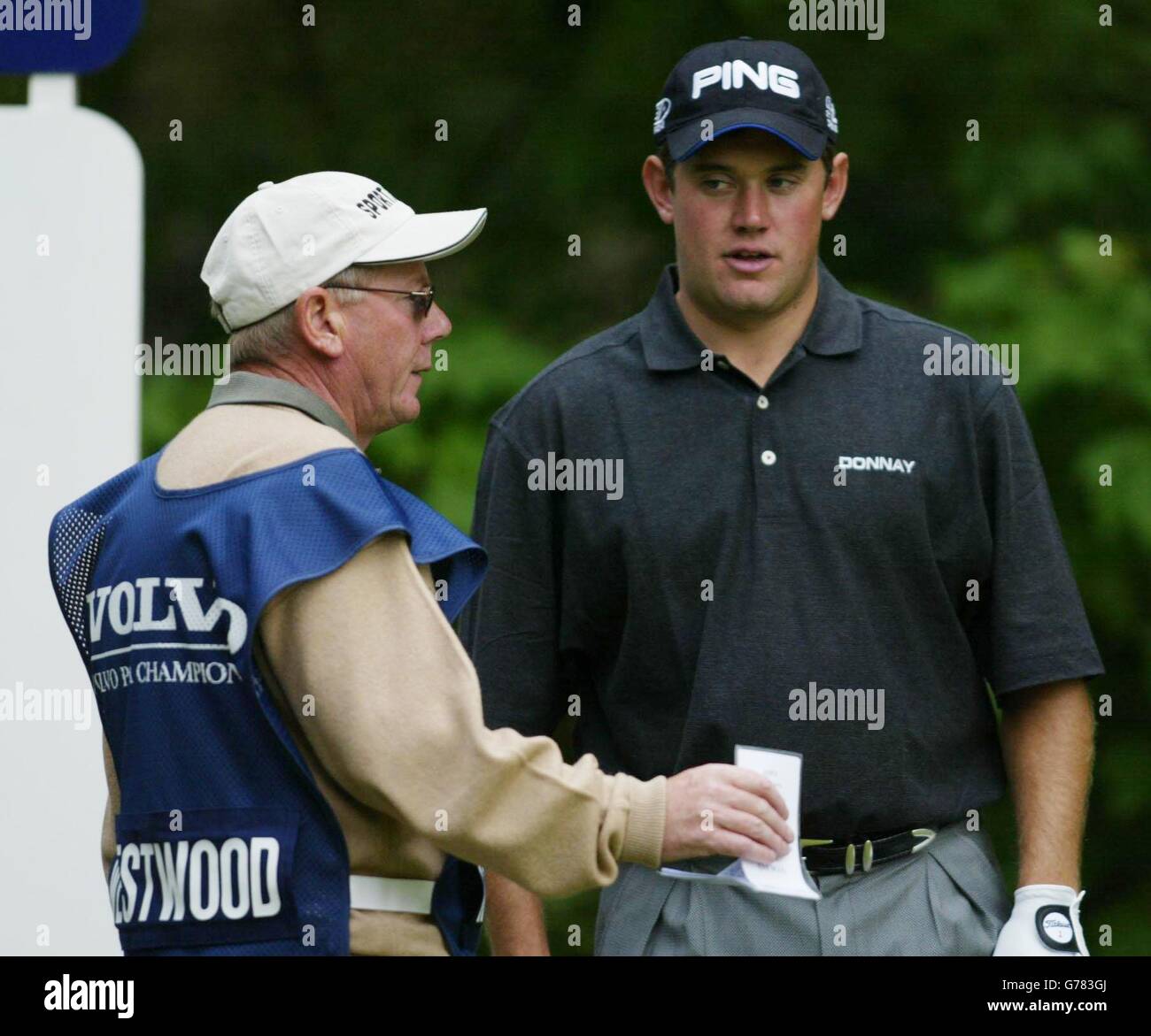 Lee Westwood (R) controlla lo yardage al 5 ° verde con caddy Dave Renwick durante il Volvo PGA Championship Pro-Am sul West Course a Wentworth. Foto Stock