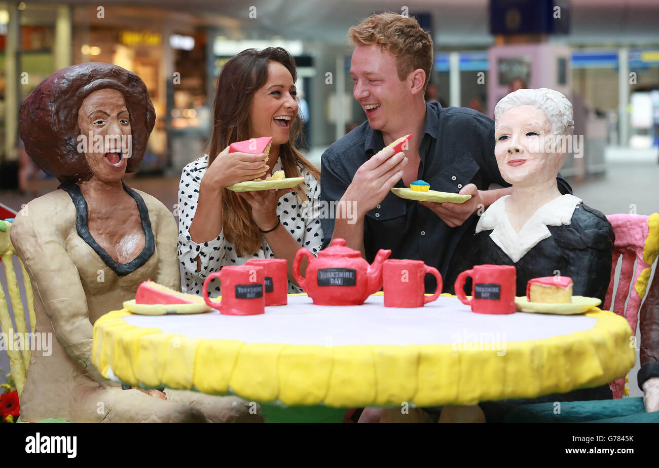 (Da sinistra a destra) Natalie Grundy e oli Carew interagiscono con lo Yorkshire Tea Party &ETH; Un'installazione di torte con Mel B e Judi Dench, insieme a Jarvis Cocker e Louis Tomlinson, commissionato da Yorkshire Tea per celebrare il 39° giorno annuale dello Yorkshire, alla stazione King's Cross di Londra. Foto Stock