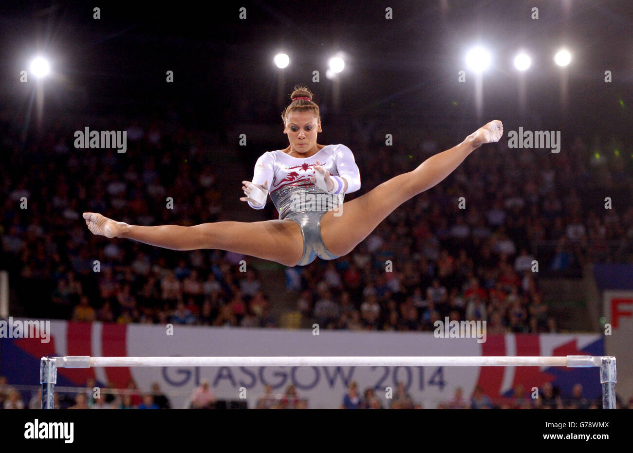 Rebecca Downie in Inghilterra compete sulle sbarre irregolari durante la finale della squadra femminile di ginnastica artistica e la qualificazione individuale al SEE Hydro, durante i Giochi del Commonwealth 2014 a Glasgow. Foto Stock