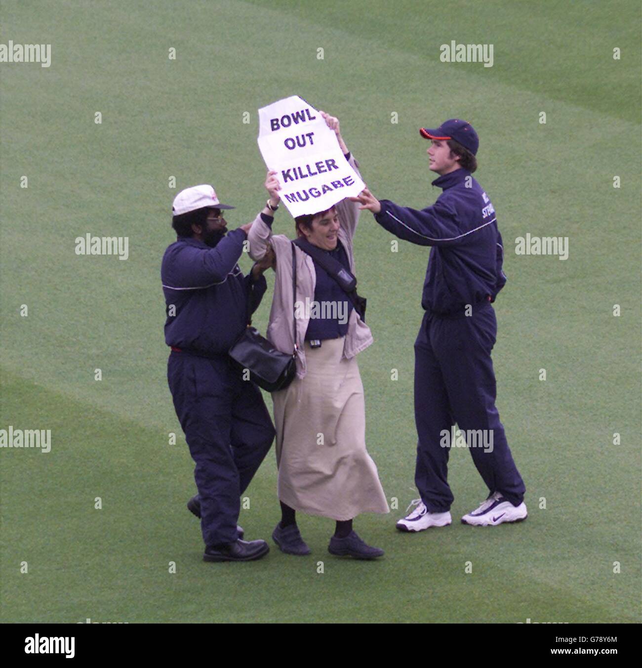 Un protetore anti Mugabe è guidato dal campo durante il primo test tra Inghilterra e Zimbabwe a Lords, Londra. *200603*UN attivista che ha interrotto una partita di cricket tra Inghilterra e Zimbabwe ha ricevuto oggi il discarico assoluto, il 20 giugno 2003. Anna Davies ha corso sul campo al Lord's durante il primo test per protestare contro il regime del presidente Robert Mugabe. Il funzionario, proveniente da Crouch End, a nord di Londra, teneva un cartello che diceva "Bowll out killer Mugabe". In precedenza, i manifestanti avevano criticato i capi di cricket per aver consentito il tour in Passi pure nonostante le violazioni dei diritti umani da parte della Foto Stock