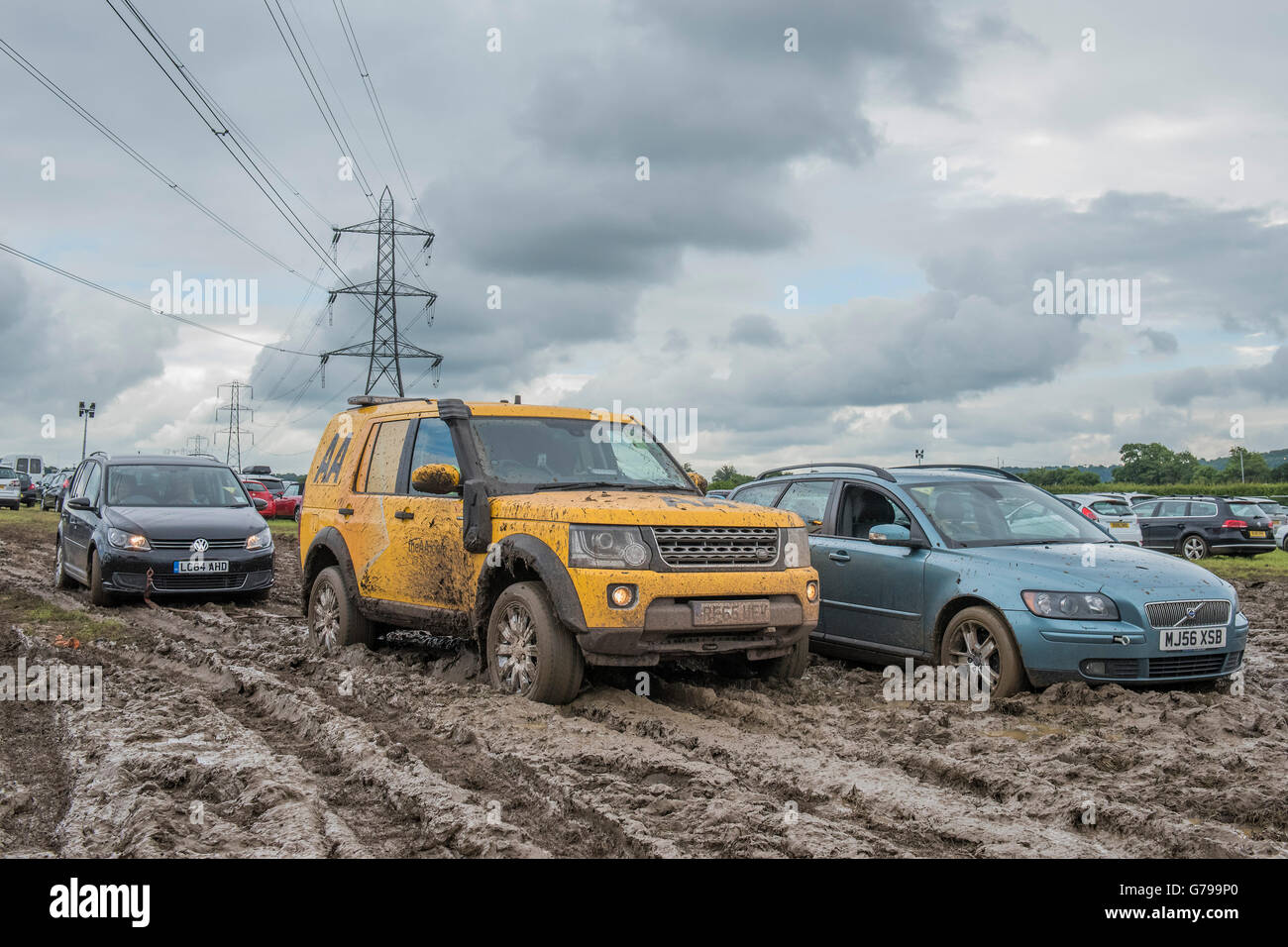 Glastonbury, Somerset, Regno Unito. Il 26 giugno, 2016. Questo AA land rover è stato bloccato per vari minuti durante il tentativo di trainare un membri auto passati che di un non membro - Festival prepararsi a lasciare il festival. AA furgoni avrebbero dovuto tirare le vetture fuori dal fango e le condizioni per la circolazione dei pedoni e automobili, uguali, sono molto fangoso (molto pesante) la mattina del giorno finale del festival dopo giorni di pioggia.Il 2016 Festival di Glastonbury, azienda agricola degna, Glastonbury. Credito: Guy Bell/Alamy Live News Foto Stock