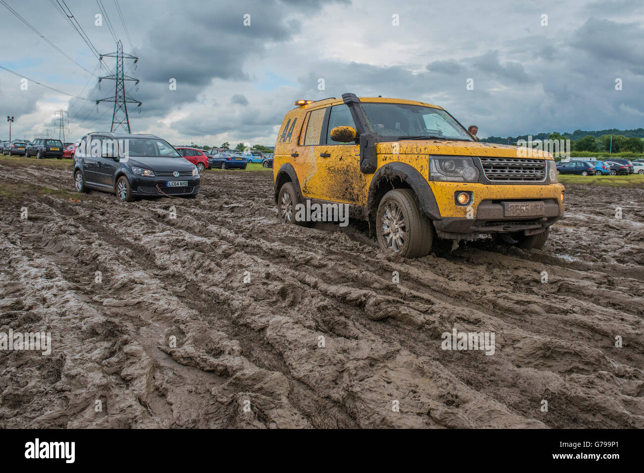 Glastonbury, Somerset, Regno Unito. Il 26 giugno, 2016. Questo AA land rover è stato bloccato per vari minuti durante il tentativo di trainare un membri auto passati che di un non membro - Festival prepararsi a lasciare il festival. AA furgoni avrebbero dovuto tirare le vetture fuori dal fango e le condizioni per la circolazione dei pedoni e automobili, uguali, sono molto fangoso (molto pesante) la mattina del giorno finale del festival dopo giorni di pioggia.Il 2016 Festival di Glastonbury, azienda agricola degna, Glastonbury. Credito: Guy Bell/Alamy Live News Foto Stock