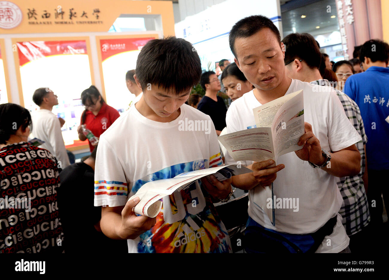 Xi'an, Shaanxi. Il 26 giugno, 2016. Un uomo e suo figlio leggere di opuscoli durante la sesta istruzione superiore expo di Cina nord-occidentale della provincia di Shaanxi in Xi'an, capitale dello Shaanxi, 26 giugno 2016. I tre giorni della fiera, che ha dato dei calci a fuori qui Domenica, ha attirato oltre 400 università e college a livello nazionale per fornire informazioni per i genitori e examinees che hanno appena partecipato nel collegio ingresso esame. questo mese. Credito: Liu Xiao/Xinhua/Alamy Live News Foto Stock