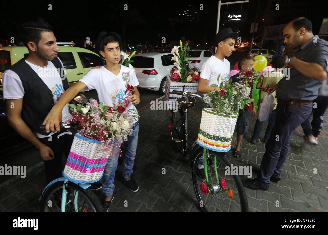 La città di Gaza, Striscia di Gaza, Territori palestinesi. Il 29 giugno, 2016. Giovani palestinesi vagare sulla colorata di biciclette e vendere fiori in strada di Gaza City, il 26 giugno 2016. Il tasso di disoccupazione nella enclave palestinese di Gaza ha aumentato drammaticamente di raggiungere circa il 45%, uno dei più alti del mondo. Come risultato della disoccupazione di lunga durata nella Striscia di Gaza, 37 per cento di Gaza a favore della gioventù (età 15-29) relazione il loro desiderio di emigrare all estero contro soltanto il 15 per cento nel 2010, secondo un sondaggio della gioventù condotte dall'Ufficio statistico centrale palestinese (PCB (credito Immagine: © Mohammed Asad/APA IMA Foto Stock