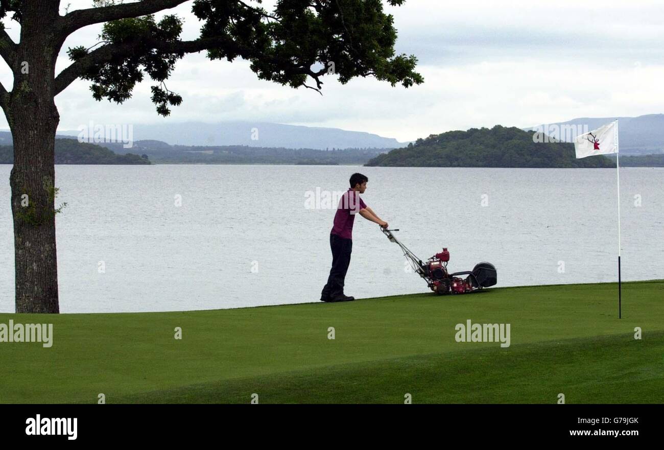 Il Green Keeper Ian Craig taglia l'erba sulla sesta buca al Loch Lomond Golf Club vicino a Balloch, in preparazione al campionato scozzese Open Golf che inizia sul campo giovedì. Foto Stock